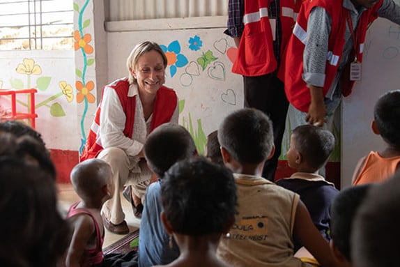 Cecile Aptel, IFRC in front of a group of children