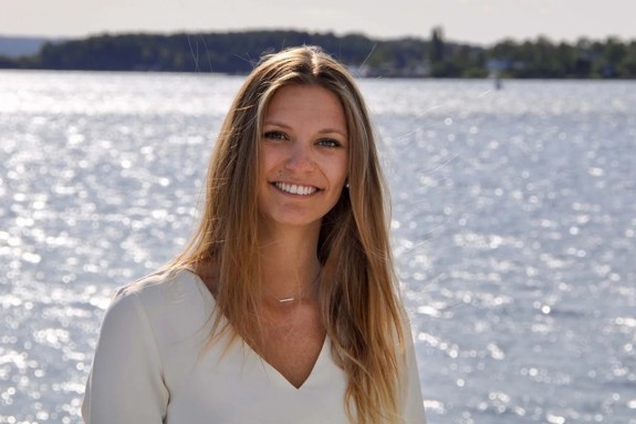 Loli Battesti smiling at the camera with a lake in the background