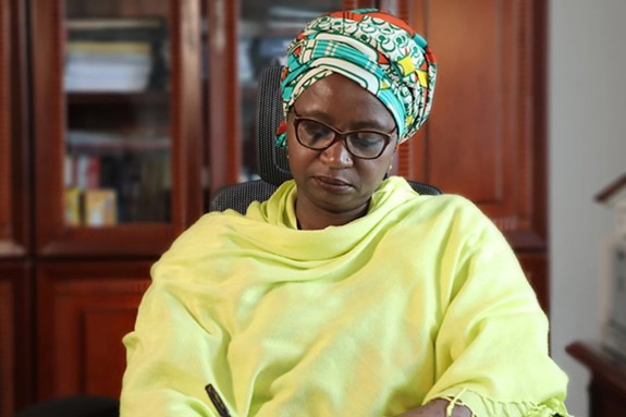 Dr. Asha Mohammed sitting on her chaise working on her desk
