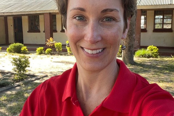 Sara Horein is smiling and looking at the camera while wearing a red Red Cross shirt.