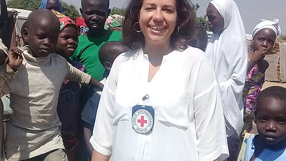 May Mousa smiling at the camera with children in the background
