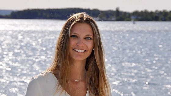 Loli Battesti smiling at the camera with a lake in the background