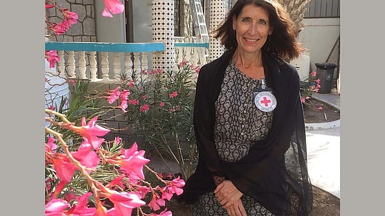 Katarina Öberg looking at the camera with flowers around her