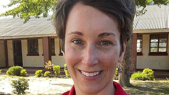 Sara Horein is smiling and looking at the camera while wearing a red Red Cross shirt.