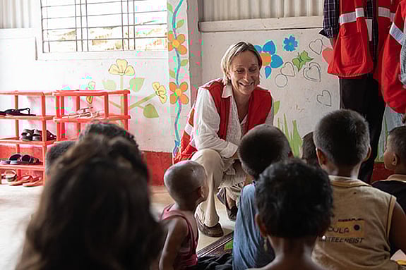 Cecile Aptel, IFRC in front of a group of children