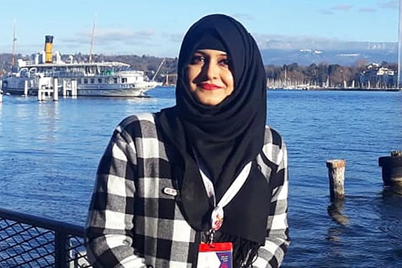 Misbah Mushtaq smiling at the camera with a port in the background