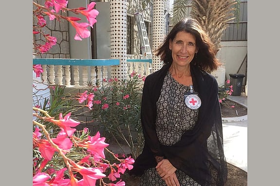 Katarina Öberg looking at the camera with flowers beside her