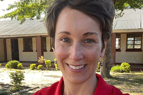 Sara Horein is smiling and looking at the camera while wearing a red Red Cross shirt.
