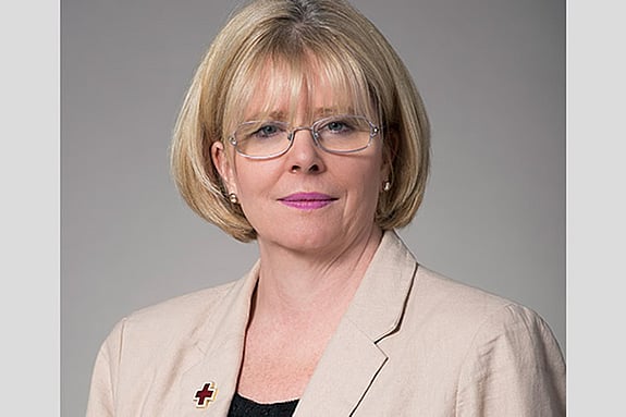 Ann Clancy smiling towards the camera with grey background
