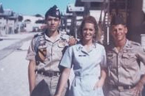 Photo of Mary Evans with two soldiers next to her smiling towards the camera
