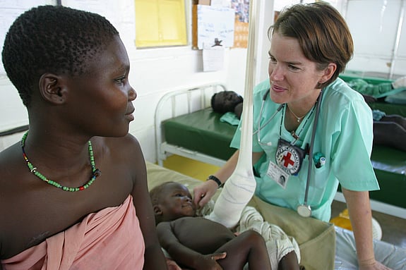 Denise Moyle, a nurse from the Australian Red Cross is attending a child and thier mother on the Kenya-Sudan border.