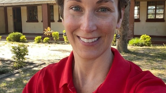 Sara Horein is smiling and looking at the camera while wearing a red Red Cross shirt.